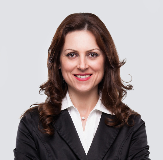 Woman in a black jacket and white shirt smiling