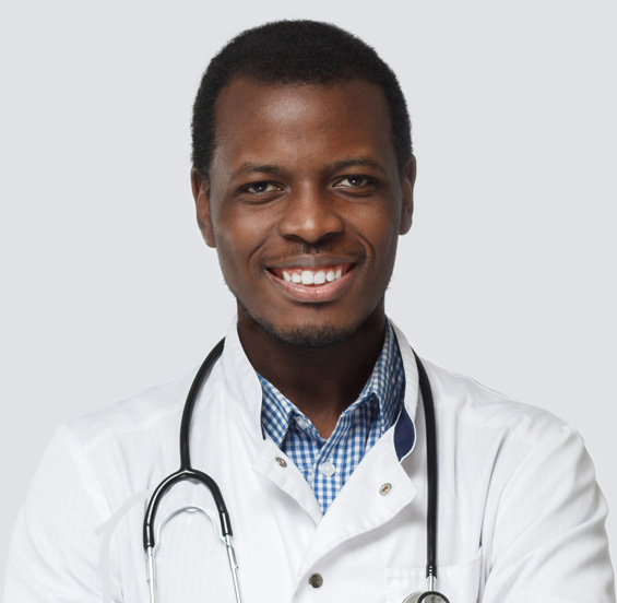 A man in a lab coat with a stethoscope smiling